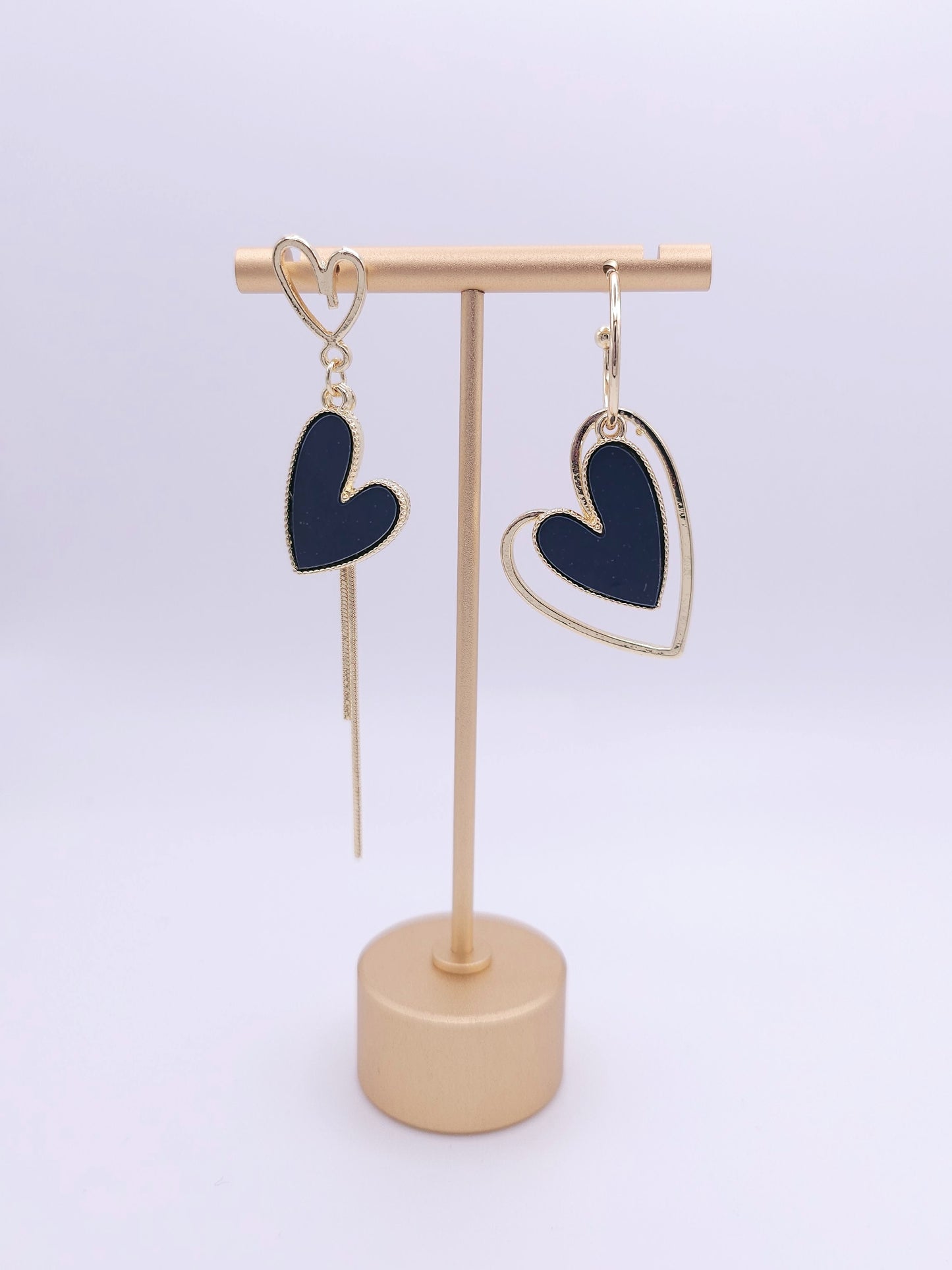 Bold black heart dangle earrings with gold accents.