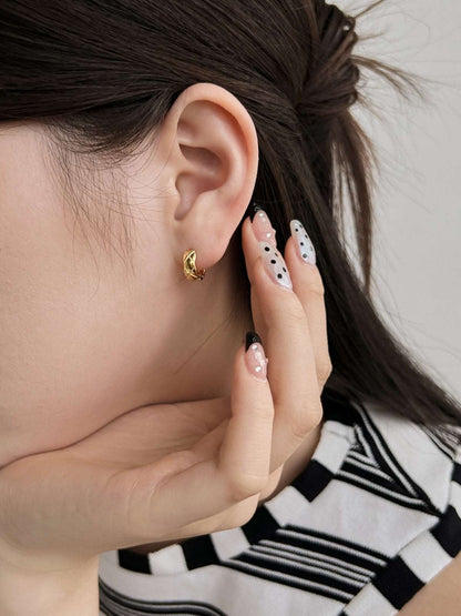 Close-up shot of a model in gold Embossing Huggie Earrings, highlighting the textured design and luxurious gold plating.