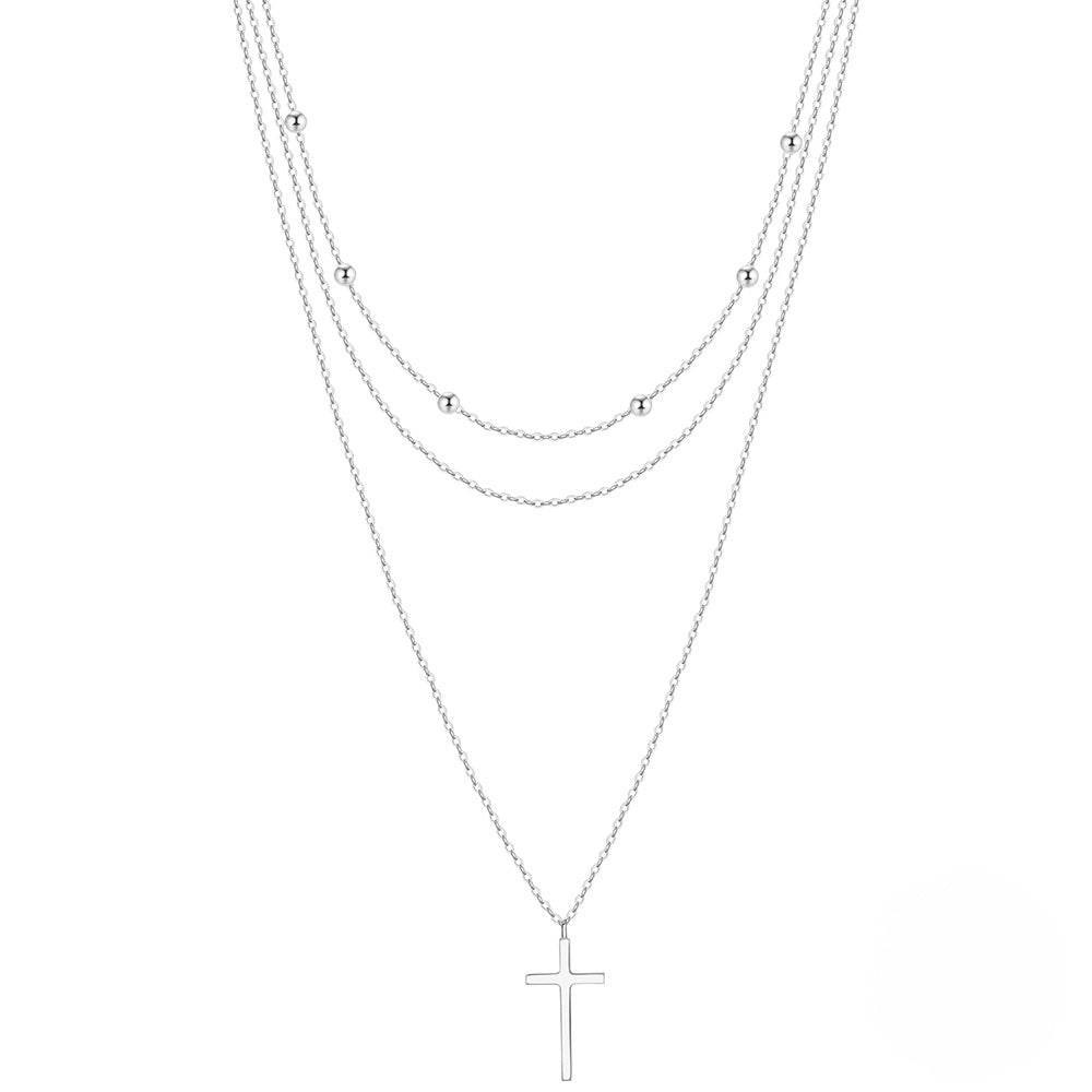 Triple layered silver necklace with cross pendant in two colors.