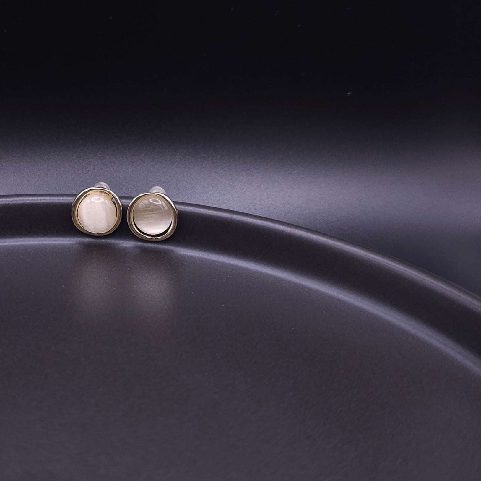 Front shot of the Glass Ball Earrings, highlighting the semi-transparent stone encased in a chic gold outline.