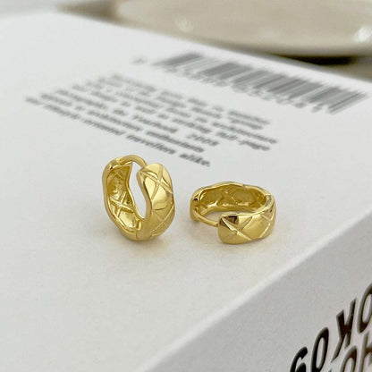 Side angle view of gold Embossing Huggie Earrings, showcasing their modern design and radiant gold finish.