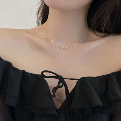 A model wearing the Gold Point Necklace, demonstrating its chic style and perfect fit around the collarbone.