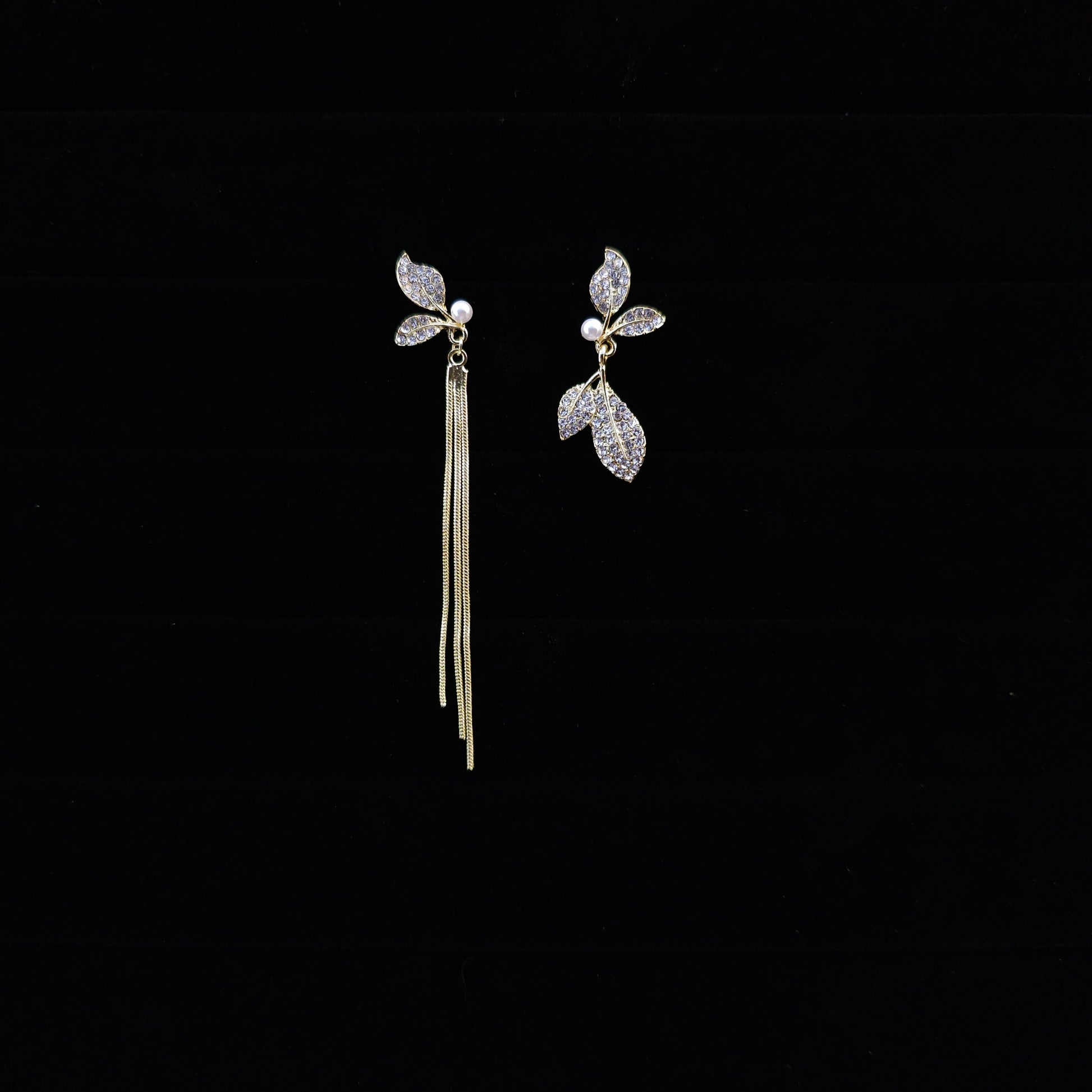 Front view of Sparkling Leaf Whispers Earrings on a black background.