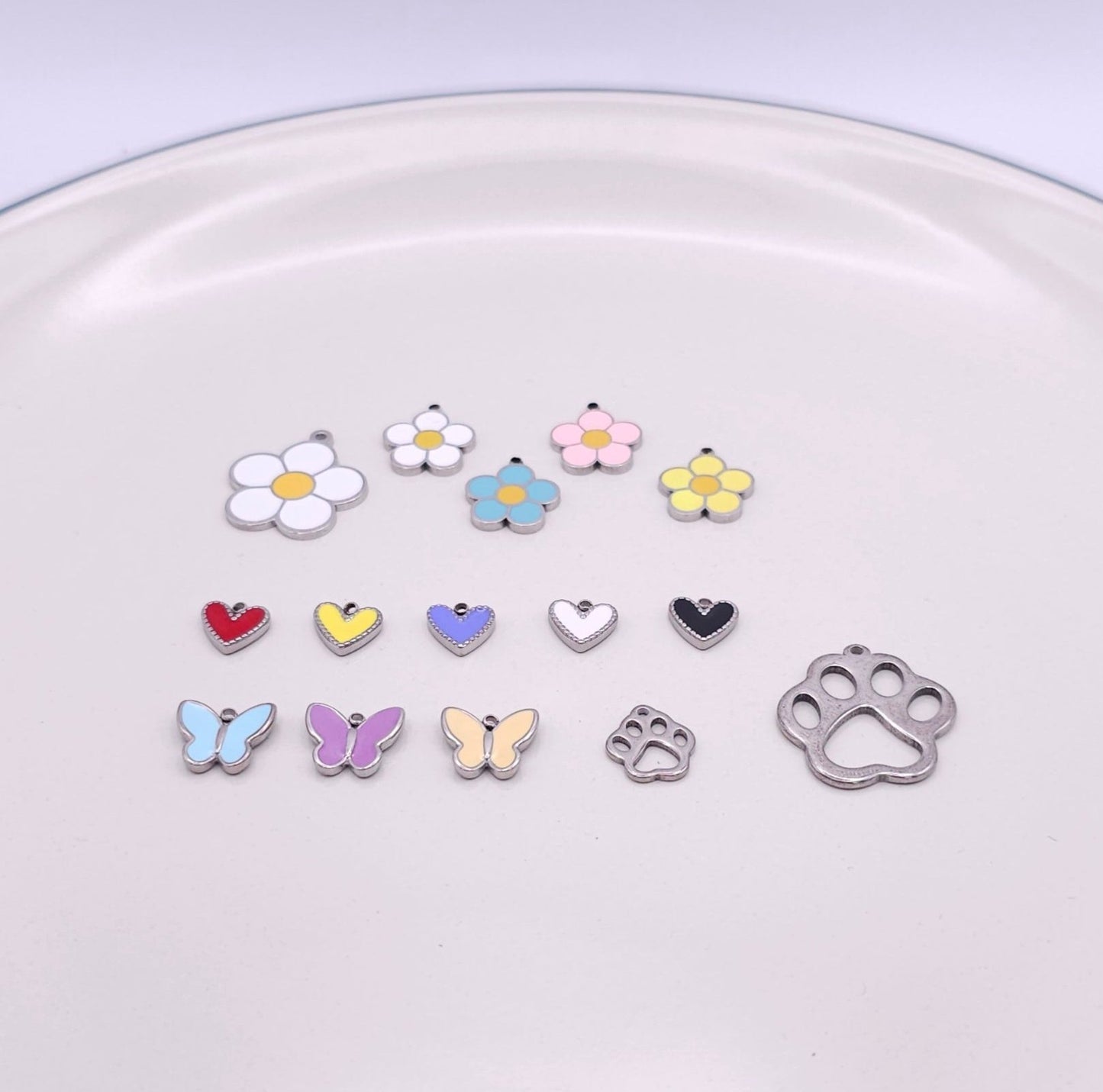 Variety of stainless steel charms for pet necklace, including whimsical shapes like bones and stars, perfect for customizing your pet necklace