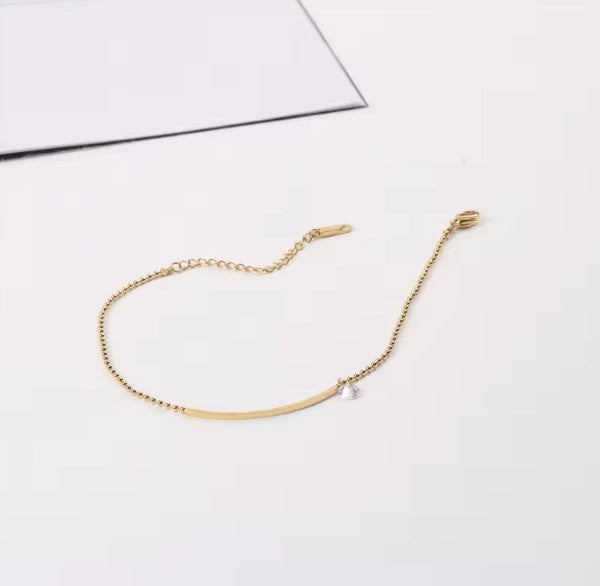 Stylish anklet featuring a bar pendant that resembles a smiley lip when worn, crafted from durable stainless steel and elegantly plated with 18k gold.